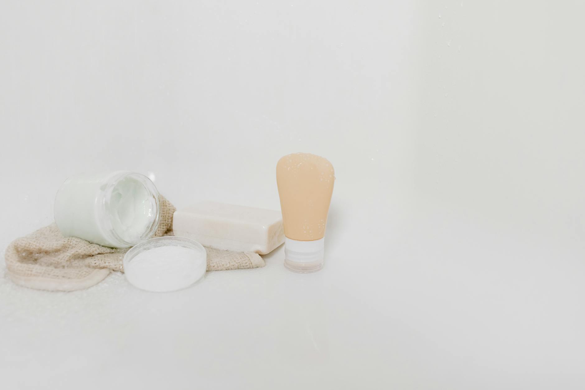 Minimalist arrangement of skincare products on a white surface, representing the simple essentials needed for post-procedure recovery