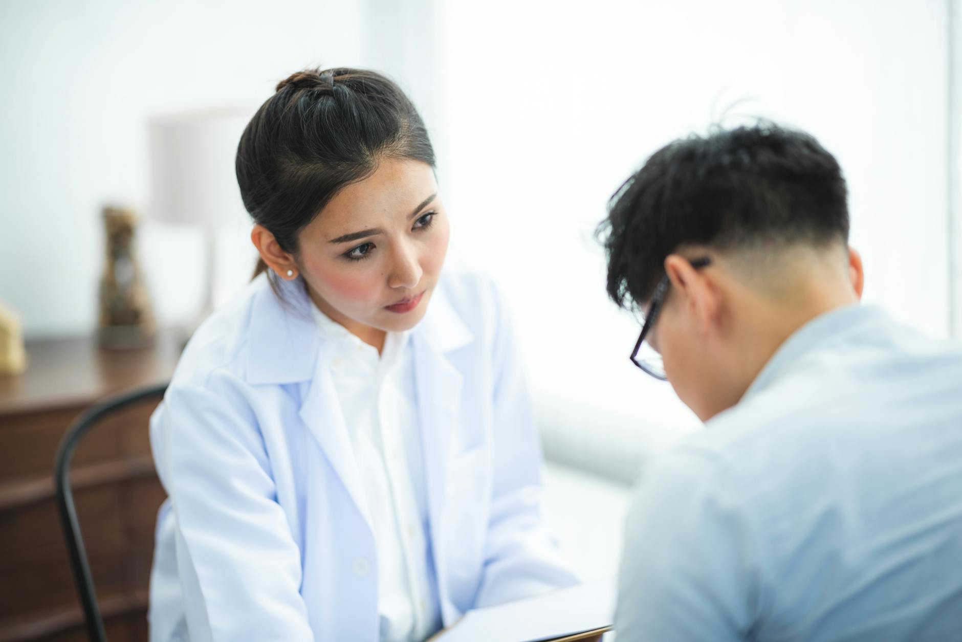 A doctor attentively listens to a patient during a medical consultation about cosmetic treatment options