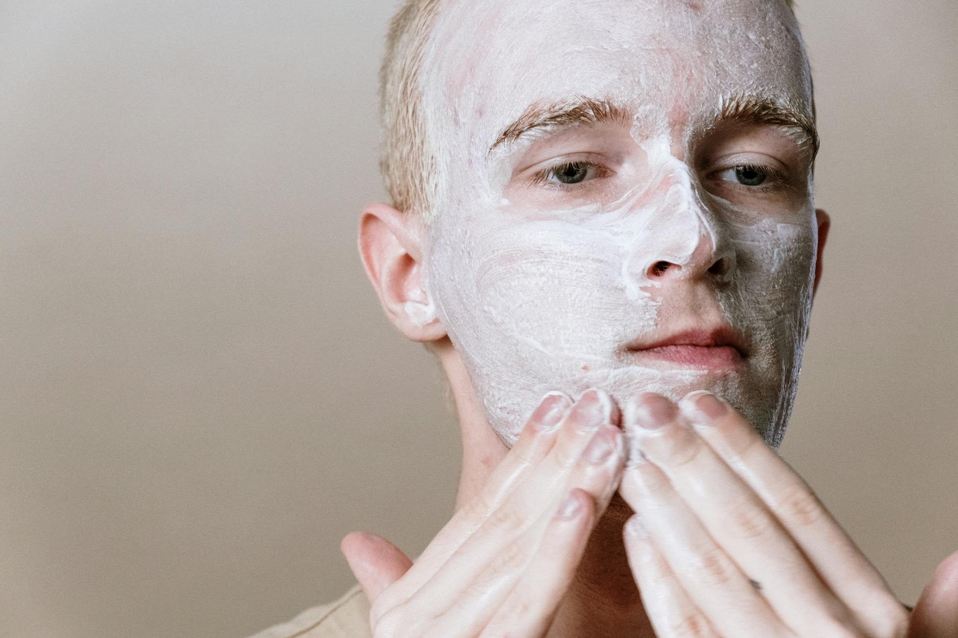 Close-up of a man applying facial cleanser as part of a daily skincare routine