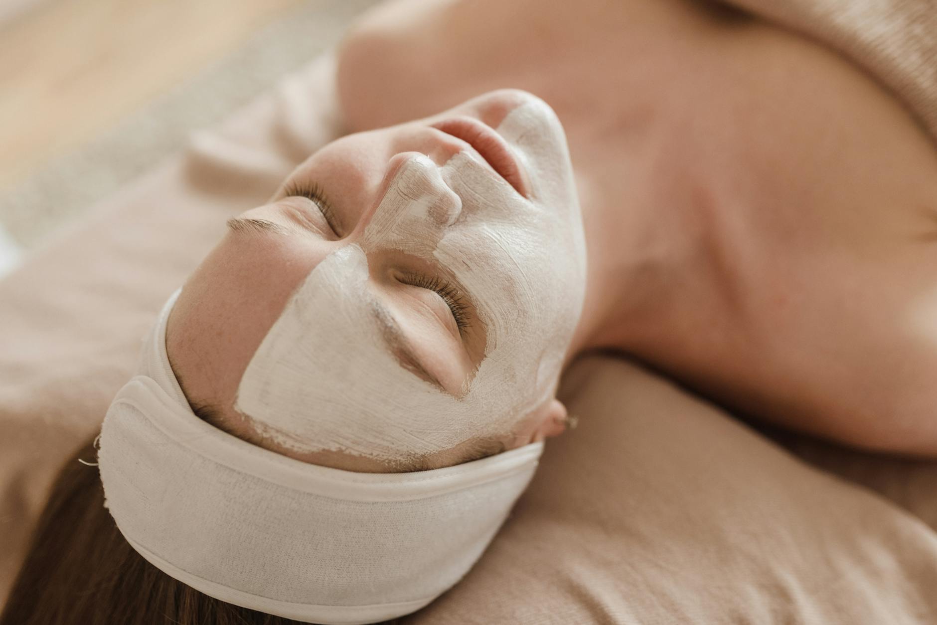 A woman enjoying a professional skincare treatment with a facial mask at a spa