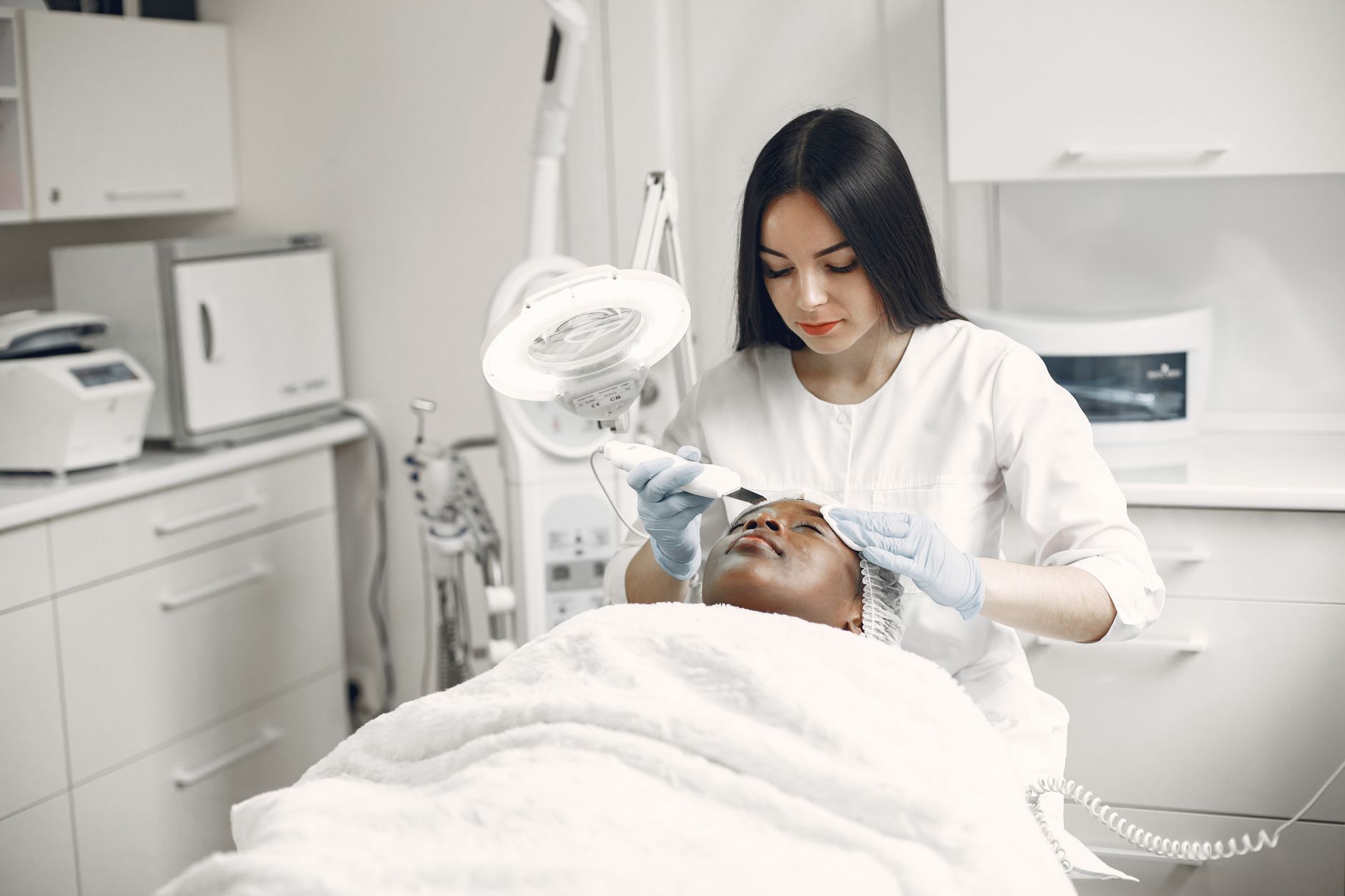 A practitioner performing a facial aesthetic treatment on a client in a clinic